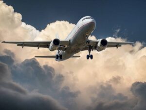 Avião voando representa o início de voos de companhia low cost no Brasil.