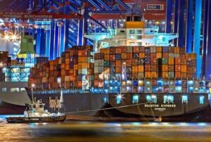 Navio cargueiro transportando contêineres no comércio internacional chinês, simbolizando o crescimento de 10% registrado em setembro.