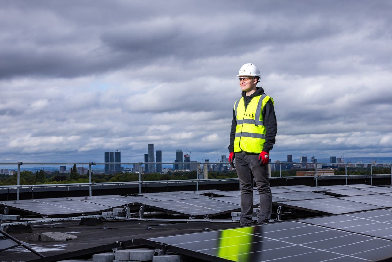 Homem no telhado de uma casa com painéis solares, olhando para o sol, representando a inovação das franquias Getpower Solar no setor de energia fotovoltaica.