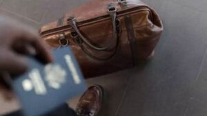Homem com passaporte ao lado de bolsa de viagem, simbolizando o melhor seguro viagem do Brasil