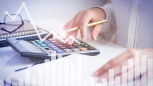 Pessoa usando calculadora para gestão financeira, ilustrando a diferença entre despesas fixas e variáveis.