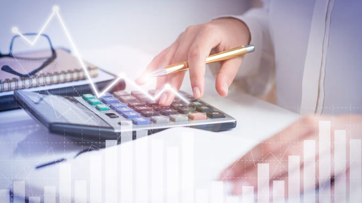 Pessoa usando calculadora para gestão financeira, ilustrando a diferença entre despesas fixas e variáveis.