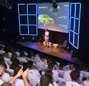 Imagem do palco do evento de lançamento do ORA 03 elétrico pela Great Wall Motor, destacando o investimento no Brasil e o compromisso com a eletromobilidade sustentável.