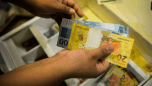 Imagem de uma pessoa contando dinheiro para representar a matéria da Arrecadação da União em setembro.