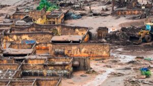 Imagem da destruição da barragem de Mariana em 2015 para ilustrar uma reportagem sobre o acordo bilionário. Na imagem, é possível vê as casas destruídas e com lama.