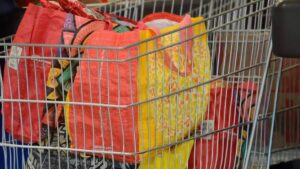 Imagem de um carrinho com bolsas de compras para representar a matéria da Confiança do Consumidor Brasileiro
