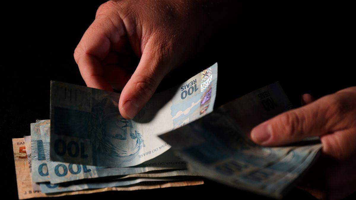 Imagem de um pessoa contando dinheiro para representar a matéria da conta corrente no Brasil e déficit e contas públicas