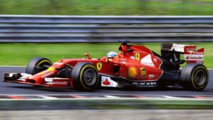Imagem de um carro vermelho de Fórmula 1 correndo em um circuito.