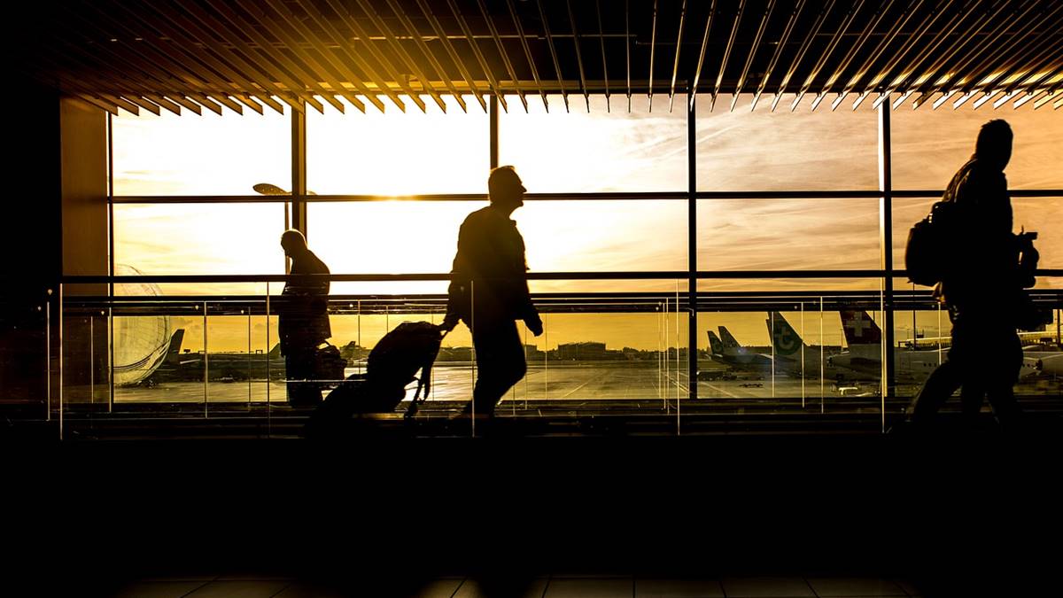 Imagem de passageiros em aeroporto ao entardecer. Brasil ocupa a quarta colocação em ranking mundial de voos domésticos
