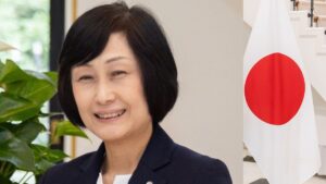 Imagem de Mitsuko Tottori , a nova CEO (presidente) da Japan Airlines. Ao lado, uma bandeira do Japão.