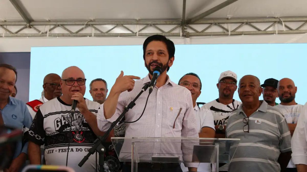 Imagem de Ricardo Nunes, eleito prefeito de São Paulo em um palanque ao lado de apoiadores.