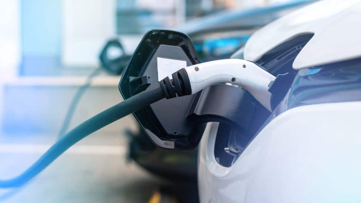 Veículo elétrico branco sendo carregado