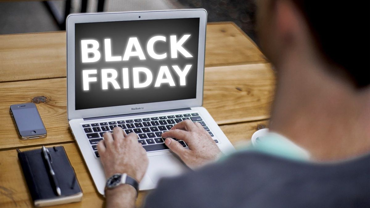 Imagem de um homem usando um notebook com a frase Black Friday na tela. A foto é para ilustrar uma matéria jornalística sobre as projeções econômicas do Black Friday 2024 e sobre o Natal