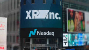 Logo da XP Inc. exibido no telão da Nasdaq, destacando o crescimento da XP Inc. em 2024 e sua relevância no mercado financeiro global.