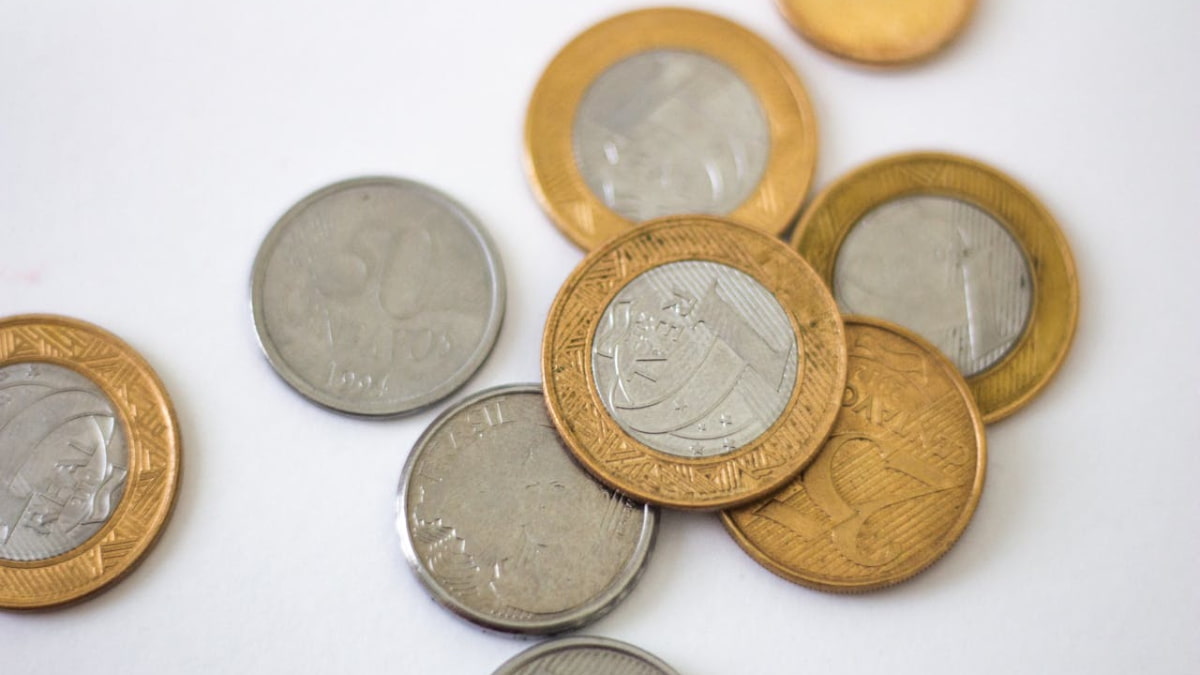 Imagem de moedas representando o impacto do déficit primário no setor público, que registrou R$ 245,6 bilhões em 12 meses, destacando desafios fiscais.