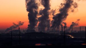 Complexo industrial produzindo grande quantidade de poluição do ar, aumentando a emissão de gases do efeito estufa. Nova meta do Brasil pretende reduzir ainda mais emissões.