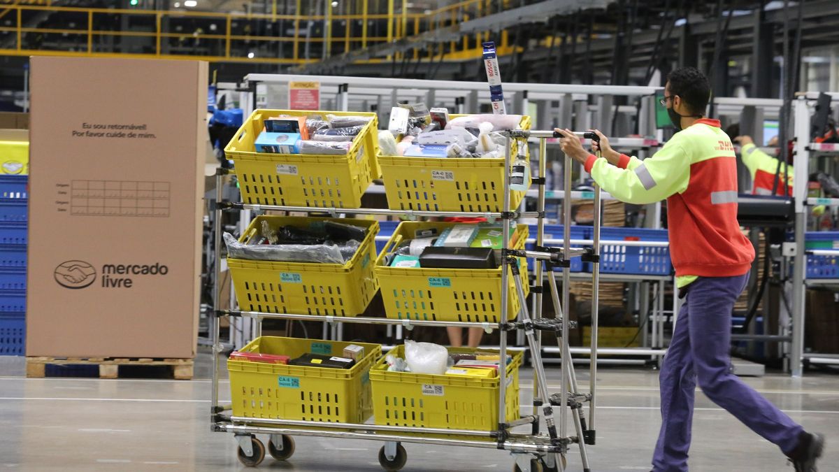 Imagem de um homem empurrando um carrinho com produtos do Mercado Livre. A imagem é para representar a matéria jornalística sobre o resultado financeiro e o lucro do Mercado Livre no trimestre.