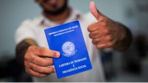 Homem negro segurando carteira de trabalho; população é a que mais sofre no mercado de trabalho.