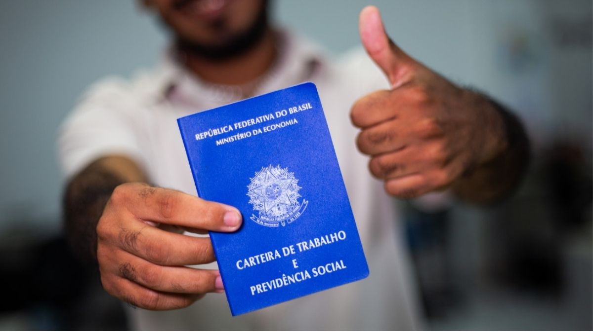 Homem negro segurando carteira de trabalho; população é a que mais sofre no mercado de trabalho.