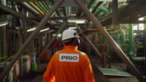 Colaborador usando uniforme laranja com logo da Prio estampada. Empresa divulgou resultados do 3º trimestre de 2024.