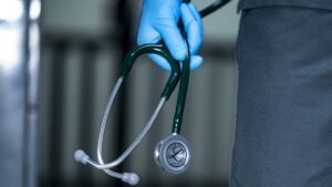 Médico segurando um estetoscópio, representando a importância dos planos de saúde em 2024 para o cuidado médico e a saúde preventiva.