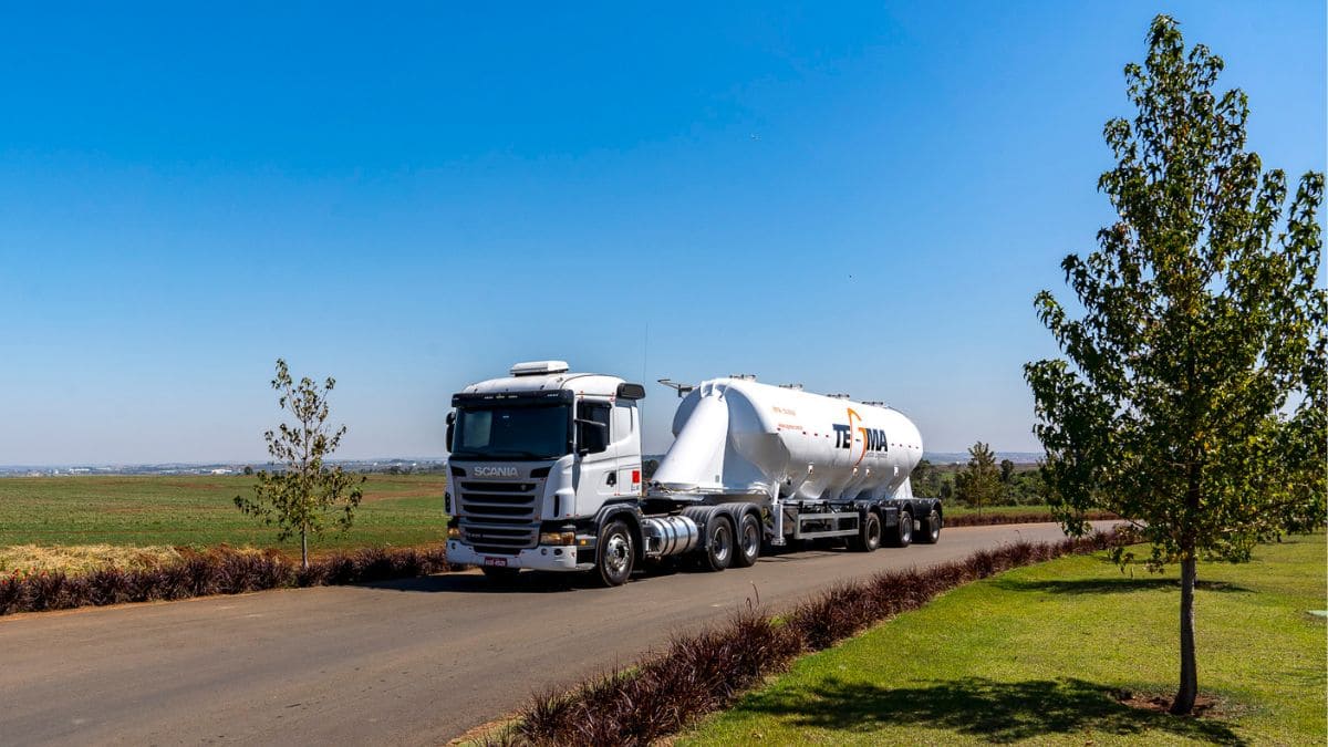Carreta da Tegma Logística em rodovia asfaltada em meio a pasto. Empresa fará pagamento de proventos referente aos resultados do 3T24