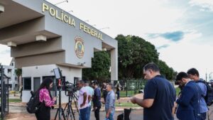 Fachada da Polícia Federal com jornalistas.