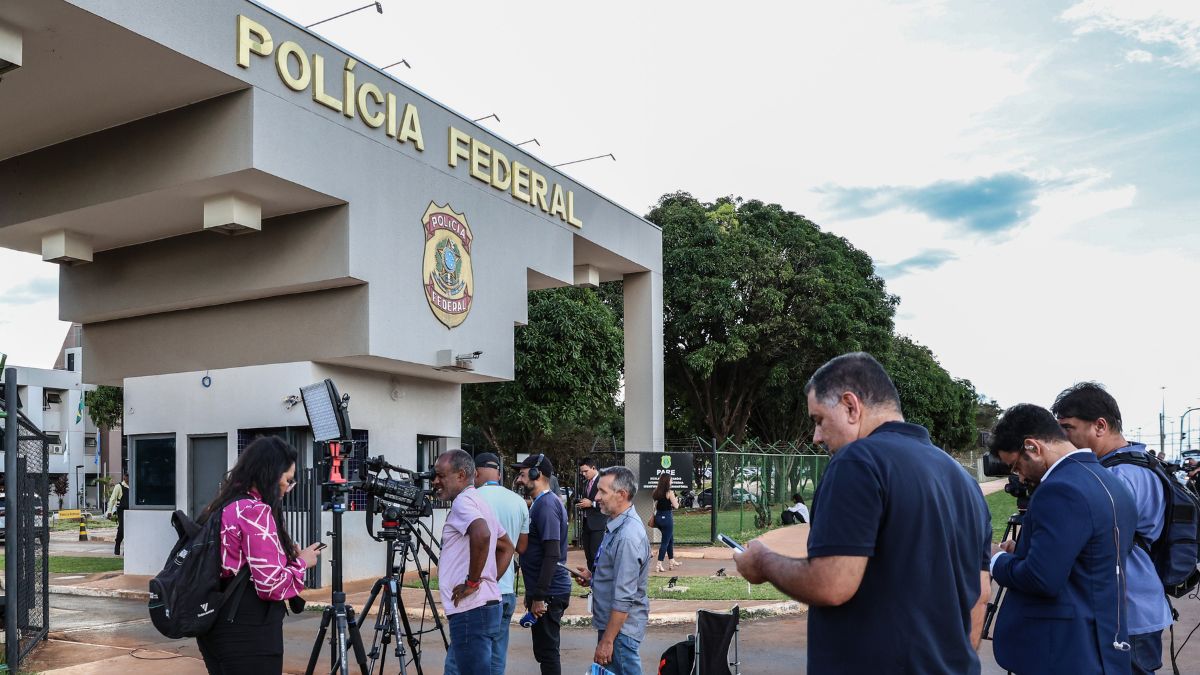 Fachada da Polícia Federal com jornalistas.