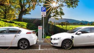 Na imagem dois carros brancos sendo recarregados por energia elétrica em alusão à aprovação de projeto de lei em São Paulo que concede isenção para veículos híbridos