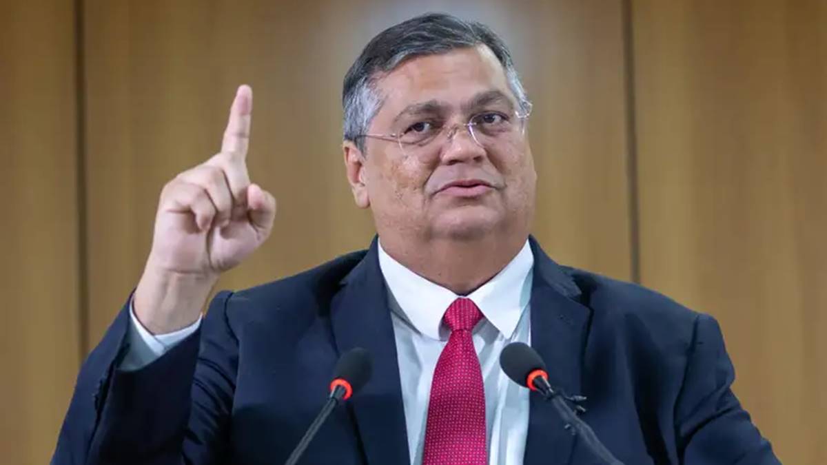 Imagem com Flávio Dino, ministro do STF, erguendo o dedo indicador da mão direita. Após questionamentos, Dino concede liberação parcial de emendas bloqueadas