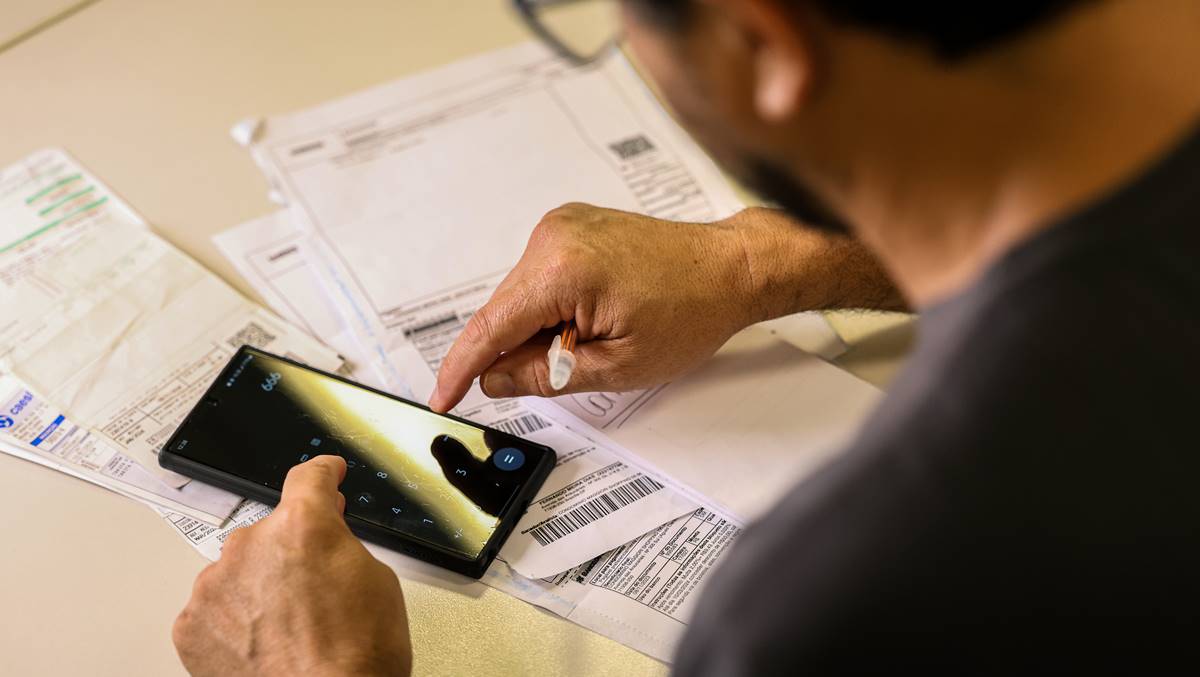 Na imagem um homem calculando contas em meio ao anúncio do Banco Central que haverá pagamentos de boletos via Pix