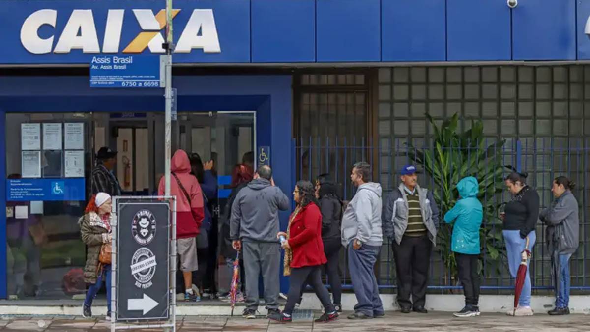 Imagem de pessoas em frente a uma agência da Caixa Econômica, que aumentou o limite para penhor