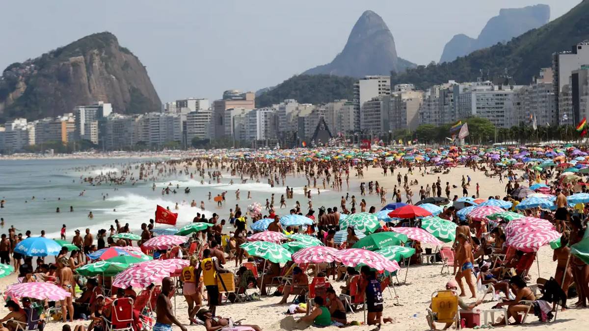 Na imagem populares em praia de Copacabana, em meio a dados que mostram que haverá mais gastos com viagens neste fim de ano de 2024