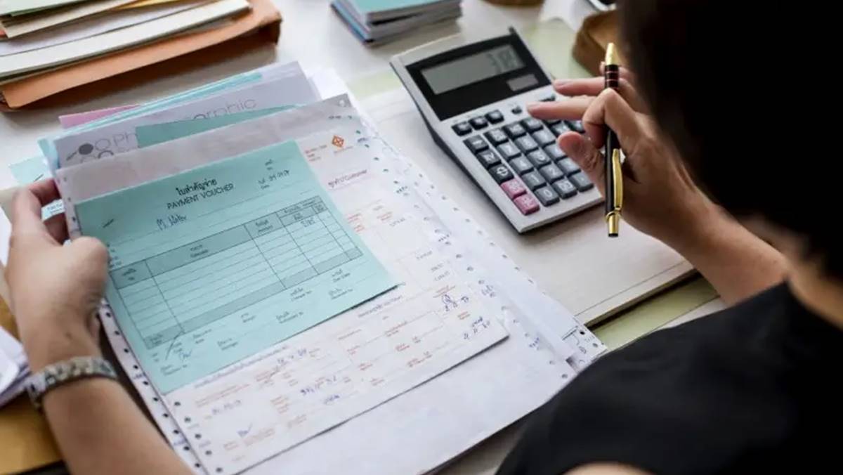 Imagem de uma calculadora e contas sobre a mesa. Inadimplência das empresas bate recorde, e dívidas disparam