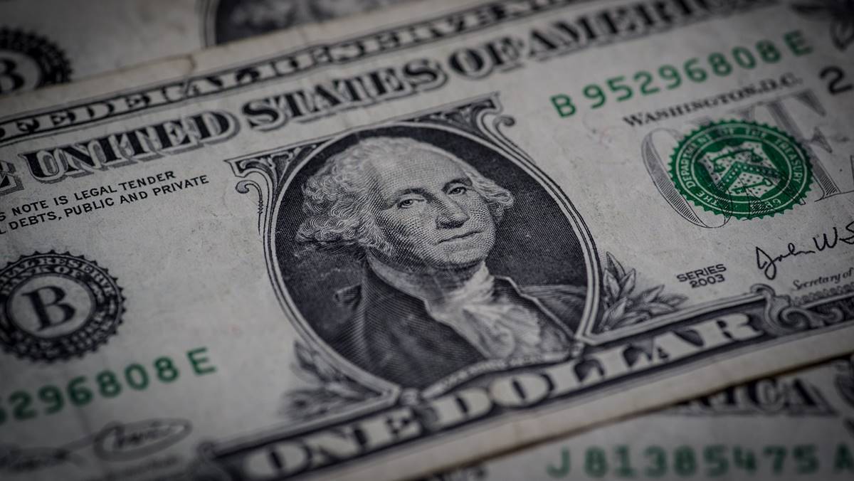 Imagem de uma cédula em dólar em meio ao fato do Senado aprovar empréstimo internacional com garantia da União