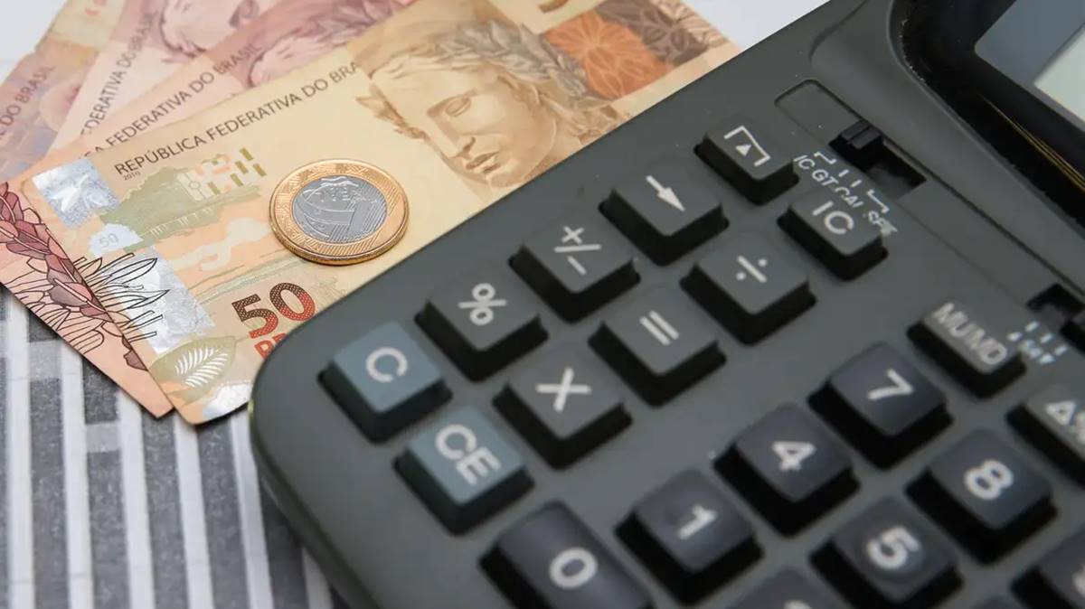 Imagem com calculadora e notas sobre a mesa. Títulos públicos atrelados à Selic tiveram alta em novembro