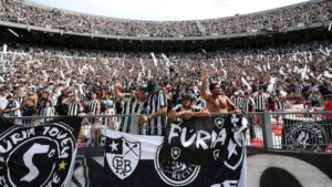 Torcedores do Botafogo torcendo no estádio de futebol.