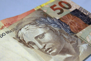 Na imagem uma nota de 50 reais sobreposta a uma de 20, em meio ao contexto sobre a proposta de isenção até R$ 5 mil