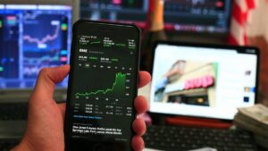 Imagem de um celula que acompanha desempenho de ações na bolsa. Ações para 2025 segundo lista do BTG Pactual