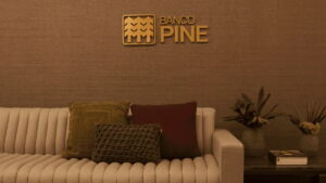 Logotipo do Banco Pine em uma parede decorativa, representando o compromisso da instituição com os acionistas ao pagar JCP