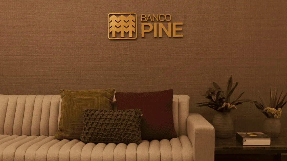 Logotipo do Banco Pine em uma parede decorativa, representando o compromisso da instituição com os acionistas ao pagar JCP