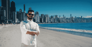 Especialista Bruno Cassola em Balneário Camboriú, com arranha-céus e praia ao fundo, representando o mercado imobiliário de Santa Catarina.