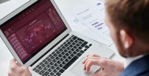 CFOs analisando dados financeiros em um laptop com gráficos e relatórios, demonstrando estratégias e tendências de crescimento para 2025.