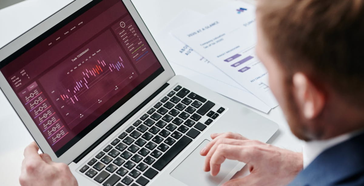 CFOs analisando dados financeiros em um laptop com gráficos e relatórios, demonstrando estratégias e tendências de crescimento para 2025.