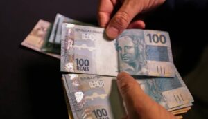 Notas de R$ 100 sendo contadas. Crédito em 2024 deve fechar com alta superior a 10%, estima Febraban
