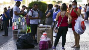 Imagem de pessoas com sacolas de compra. Estudo descarta tese de que há hipertributação dos pobres no Brasil