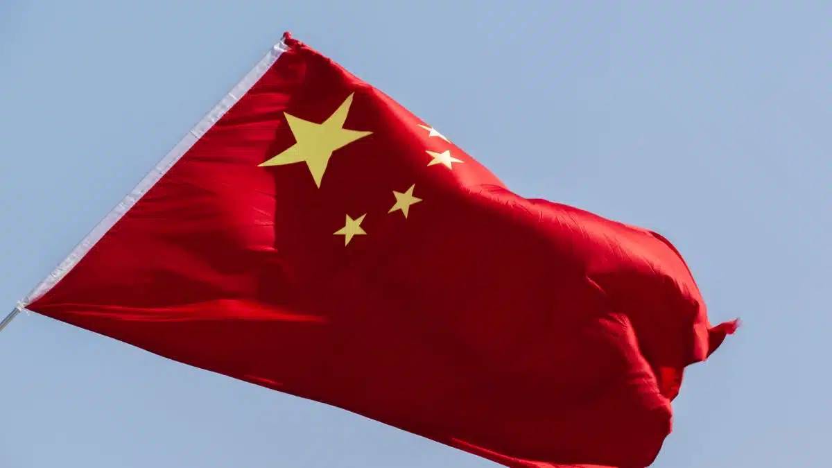 Imagem com a bandeira trêmula da China. Exportações da China crescem mais de 10% em dezembro de 2024
