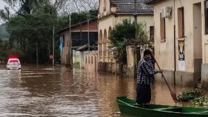 Imagem de um homem num pequeno barco pelas ruas alagadas no Rio Grande do Sul. Governo destinou mais de 2,5 bilhões para agricultura familiar no RS