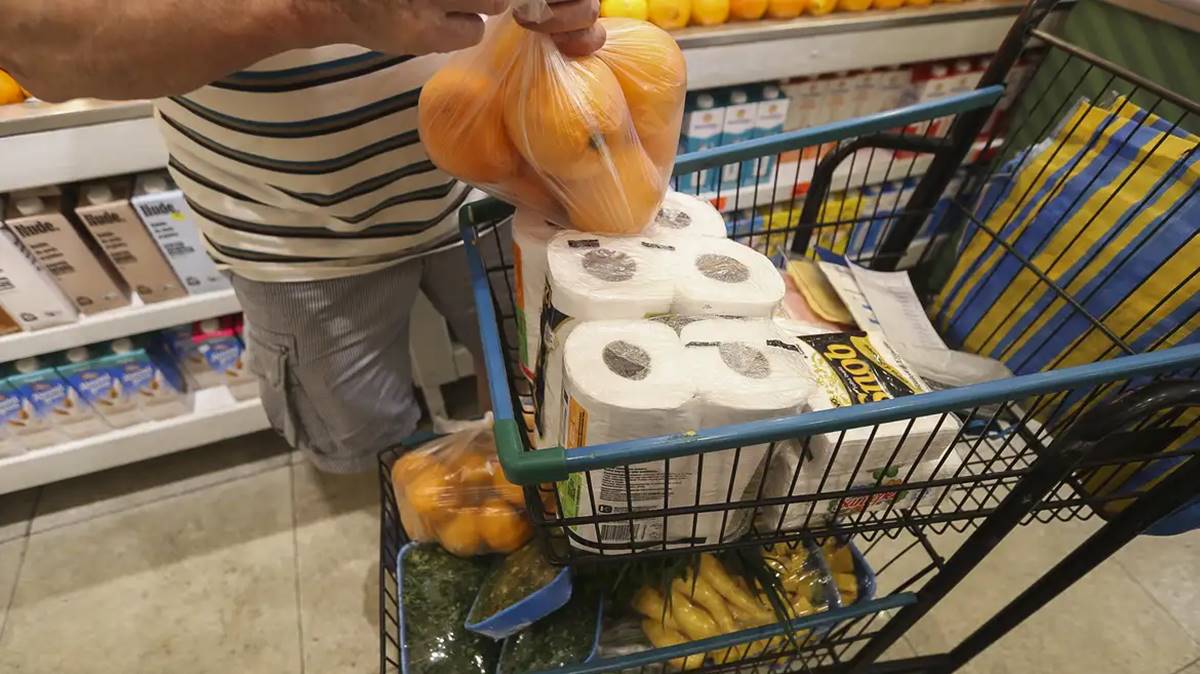 Imagem de produtos e alimento num carrinho de supermercado. Intenção de consumo das famílias registra leve alta em janeiro