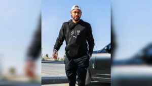 Neymar com casaco preto e de boné em dia de sol. Neymar Jr abre mão de milhões com time árabe para regressar ao Santos